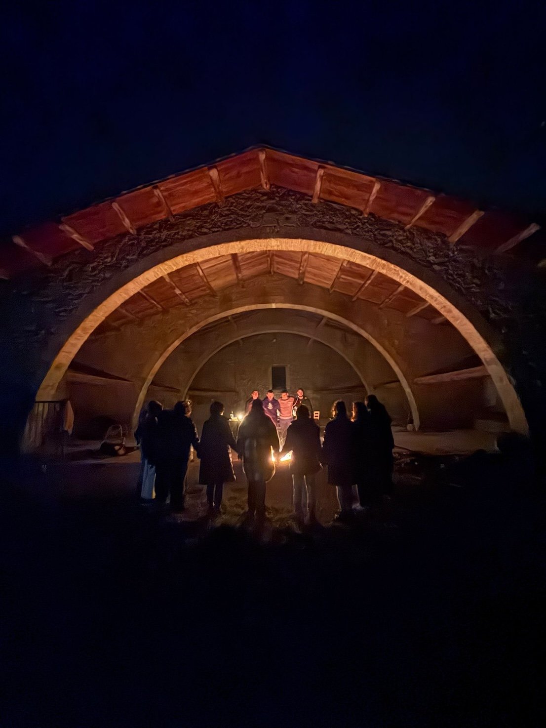 Círculo nocturno bajo el arco de piedra de Mas Besaura, Vidrà